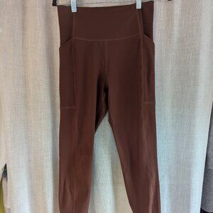 Girlfriend Collective medium brown leggings with side pockets.
